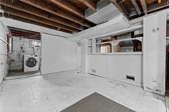 basement with light tile patterned flooring and washer / clothes dryer