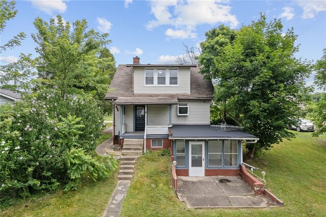 rear view of property featuring a yard and a patio