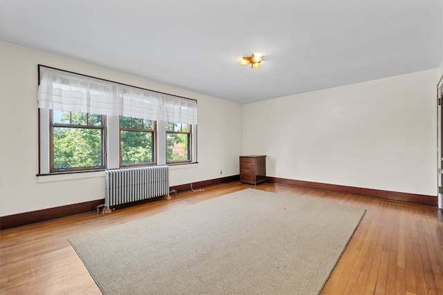 spare room with radiator and wood-type flooring