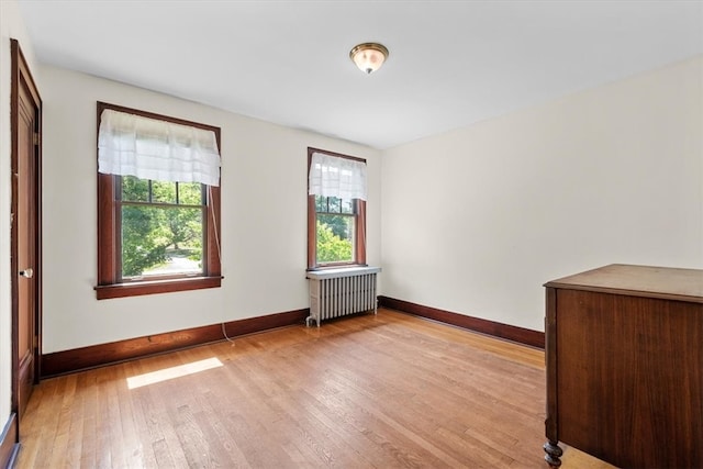 empty room featuring wood-type flooring and radiator