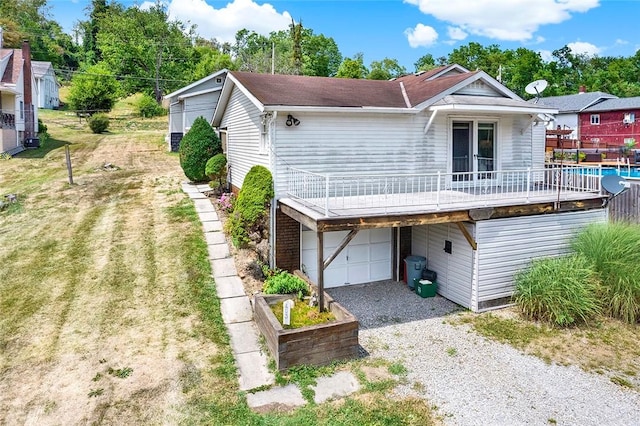 back of property with a garage and a lawn