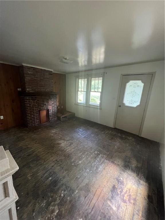 unfurnished living room with a large fireplace and dark hardwood / wood-style floors