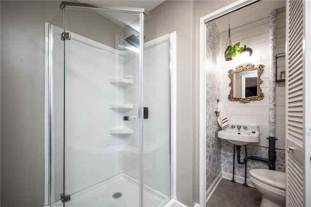 bathroom featuring tile patterned flooring, toilet, and an enclosed shower