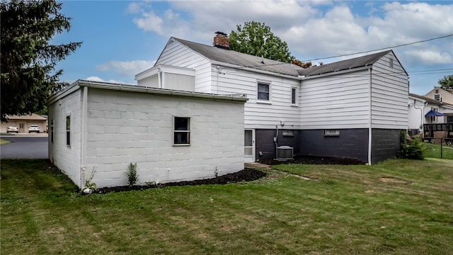 rear view of house featuring a yard and central AC unit