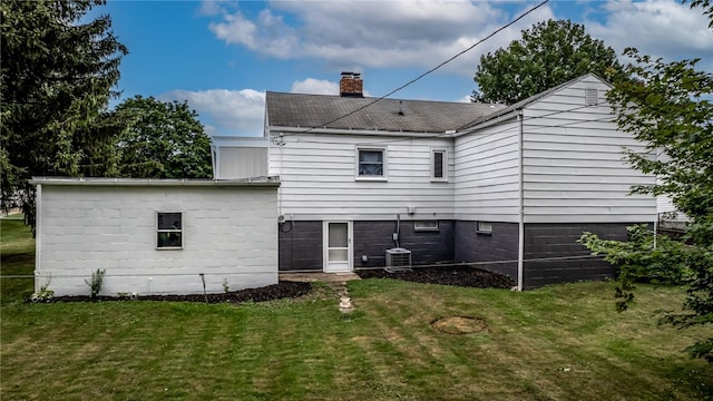 back of house featuring a lawn and central AC