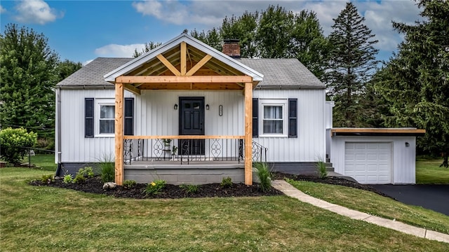 view of front facade featuring a garage, covered porch, and a front yard