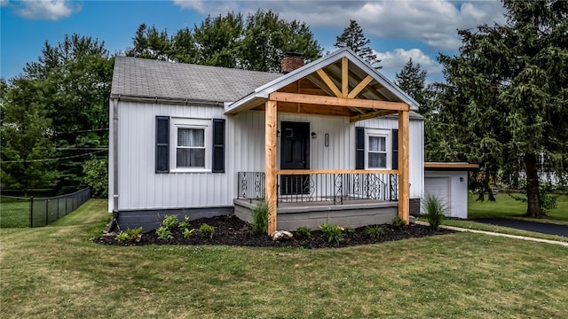 view of front of house with a porch, a garage, and a front lawn