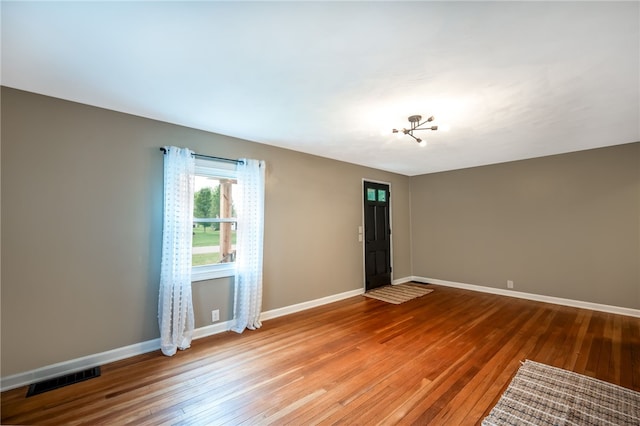 unfurnished room with wood-type flooring