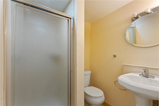 bathroom with toilet, sink, and an enclosed shower