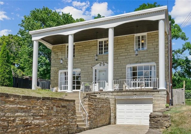 view of front of property with a garage, stone siding, and driveway