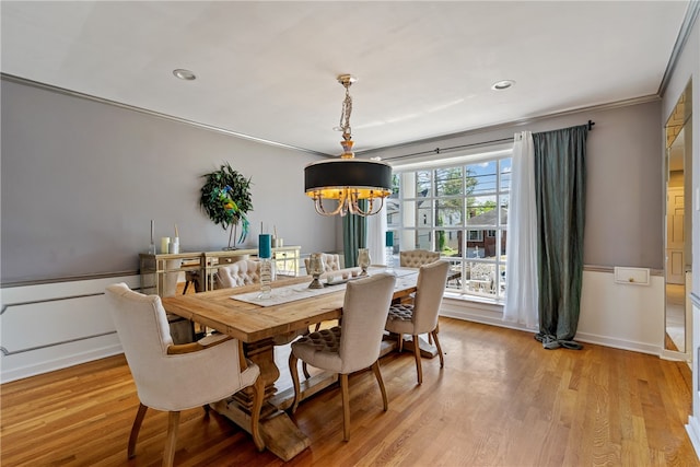 dining space featuring a notable chandelier, light hardwood / wood-style flooring, and crown molding