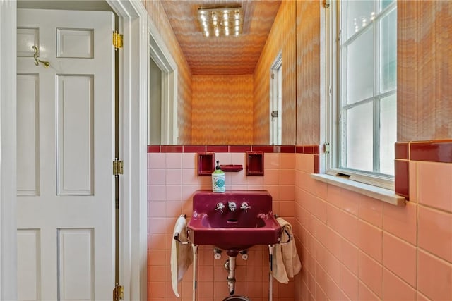 bathroom featuring a sink and tile walls