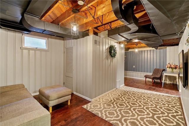 below grade area featuring wood finished floors, visible vents, and baseboards