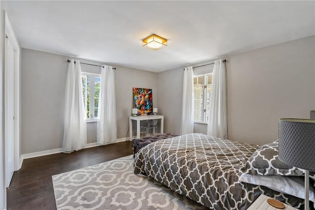 bedroom with dark wood-style flooring and baseboards