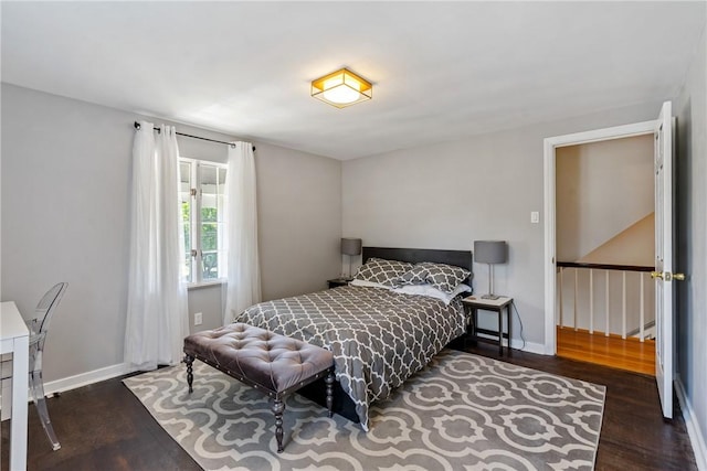 bedroom featuring dark wood-style floors and baseboards