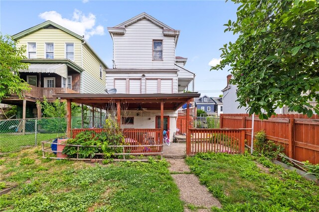 rear view of property featuring ceiling fan