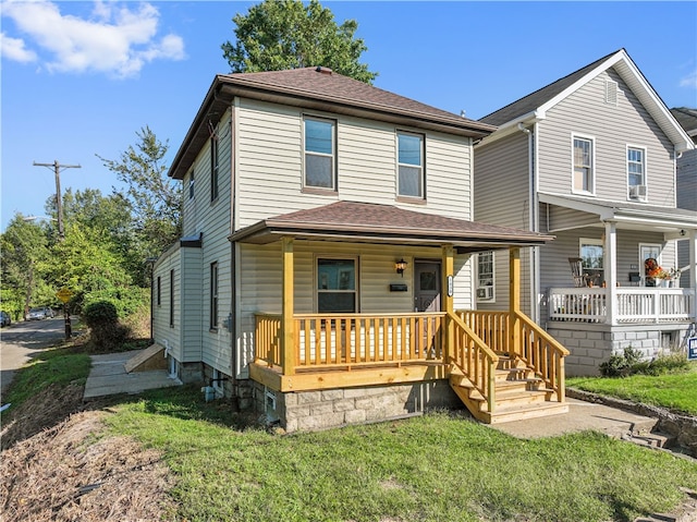 view of property featuring a front lawn and covered porch