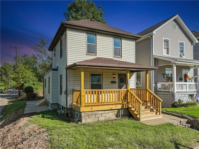 front facade with a yard and covered porch