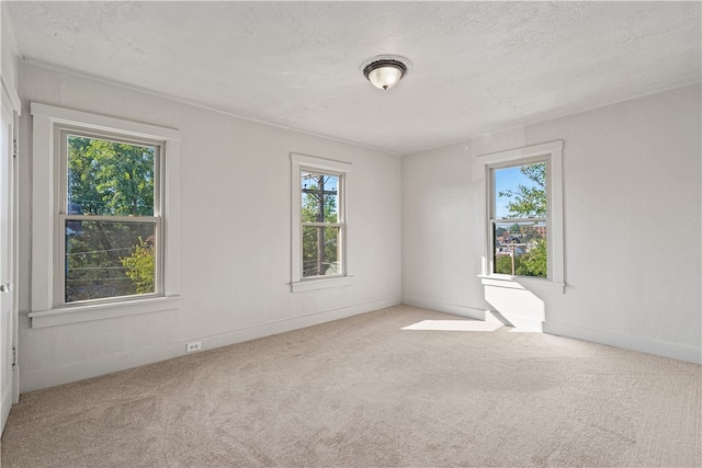 carpeted empty room with a textured ceiling