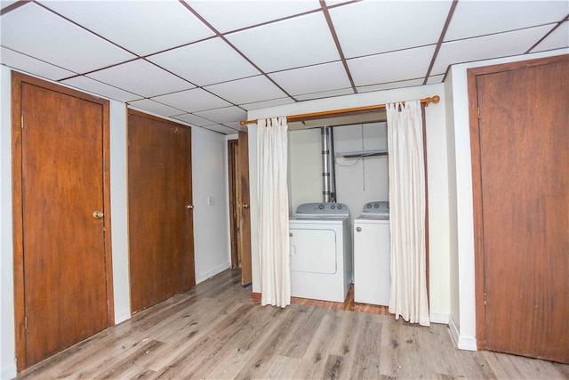 washroom with washing machine and dryer and light wood-type flooring