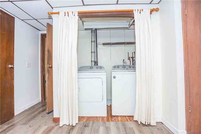 laundry room featuring independent washer and dryer and light hardwood / wood-style floors