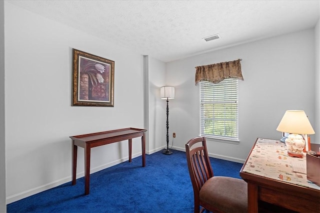 carpeted office featuring a textured ceiling