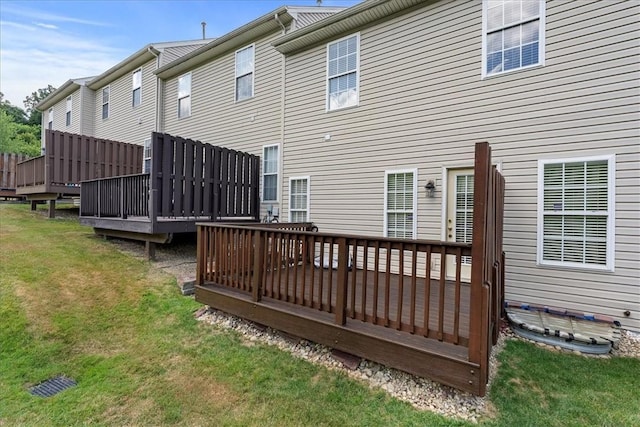 back of house featuring a yard and a wooden deck