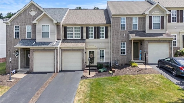 multi unit property featuring a front yard and a garage