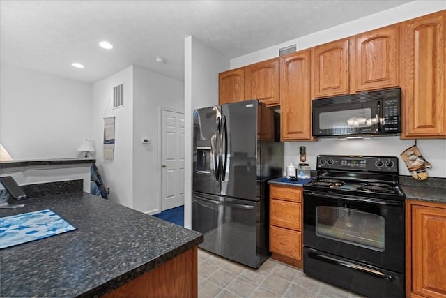 kitchen with dark stone countertops and black appliances