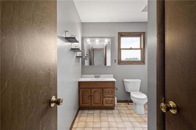 bathroom featuring vanity, tile patterned flooring, and toilet