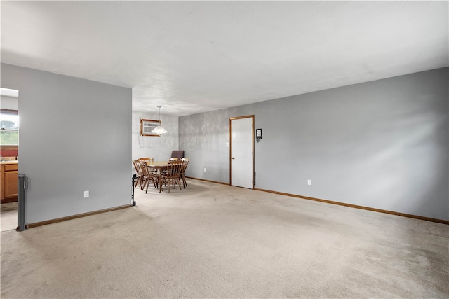 unfurnished living room with an AC wall unit and light colored carpet