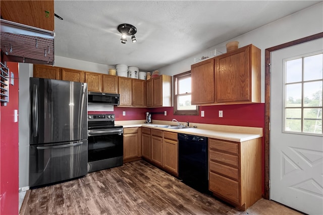 kitchen with plenty of natural light, sink, dark hardwood / wood-style flooring, and black appliances