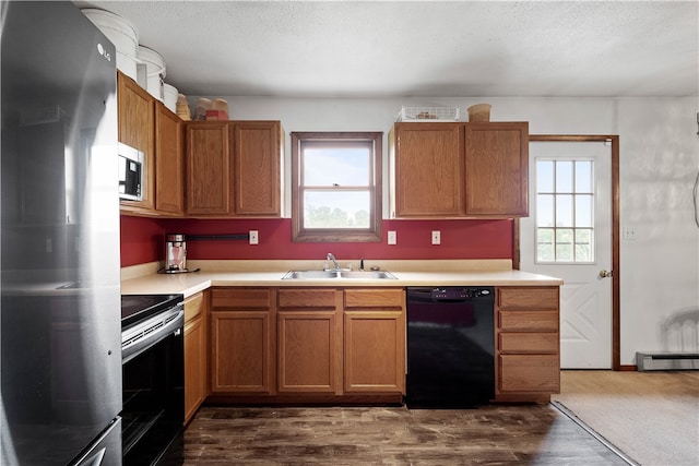 kitchen with appliances with stainless steel finishes, sink, dark carpet, and a healthy amount of sunlight