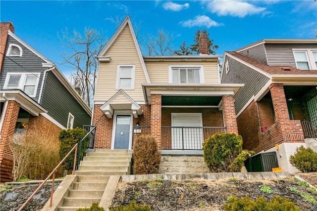 view of front of house featuring brick siding and covered porch