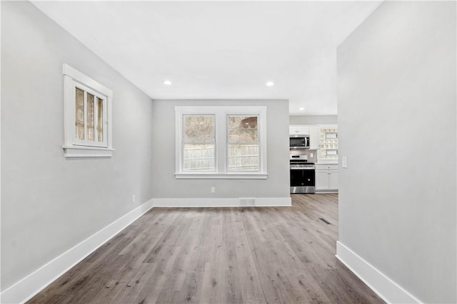 unfurnished living room featuring recessed lighting, visible vents, baseboards, and light wood-style flooring