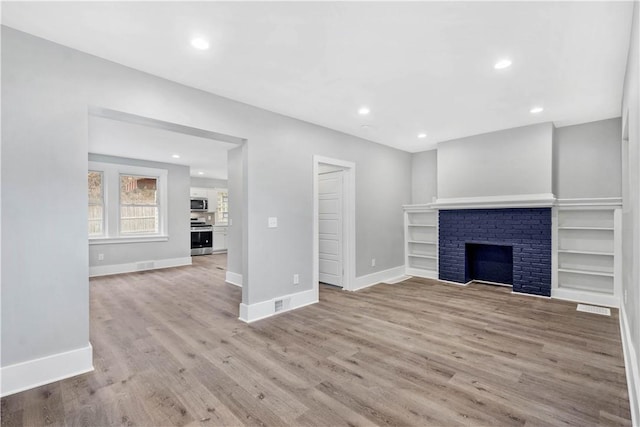 unfurnished living room featuring recessed lighting, baseboards, and wood finished floors