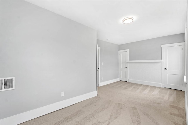 empty room with visible vents, carpet floors, and baseboards