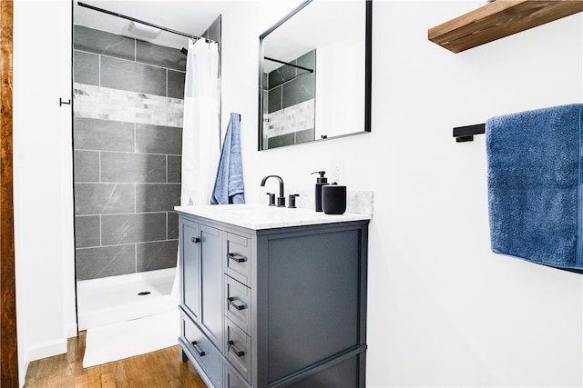 bathroom with wood-type flooring, walk in shower, and vanity