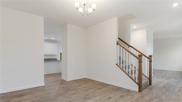 stairway with a chandelier and hardwood / wood-style flooring