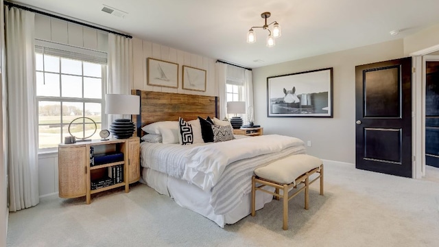 bedroom featuring a notable chandelier and light colored carpet