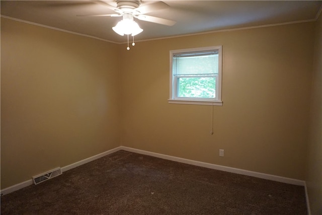 spare room with dark carpet, crown molding, and ceiling fan