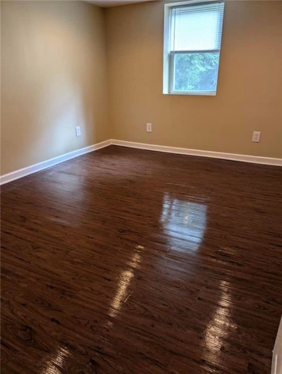 empty room with dark wood-type flooring