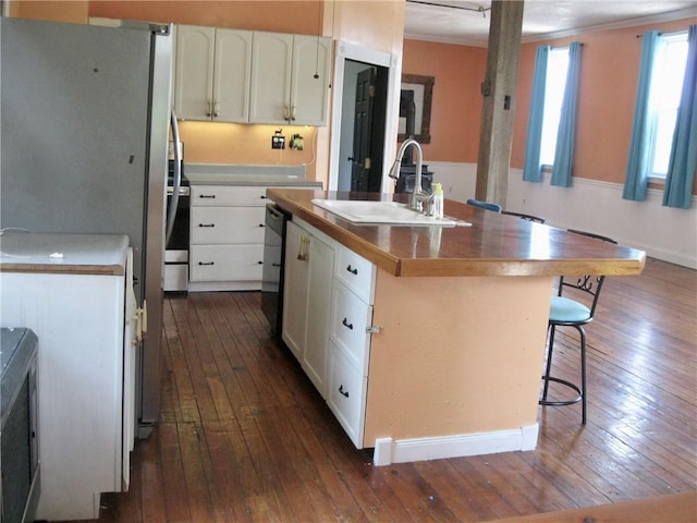 kitchen with dark hardwood / wood-style floors, white cabinetry, an island with sink, sink, and a kitchen bar