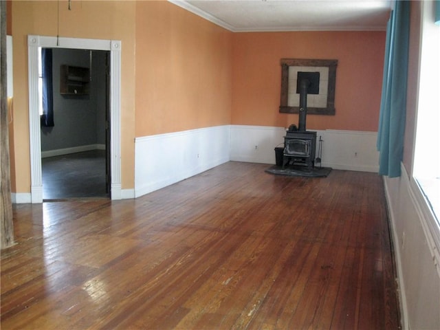 unfurnished living room with ornamental molding, dark hardwood / wood-style flooring, and a wood stove