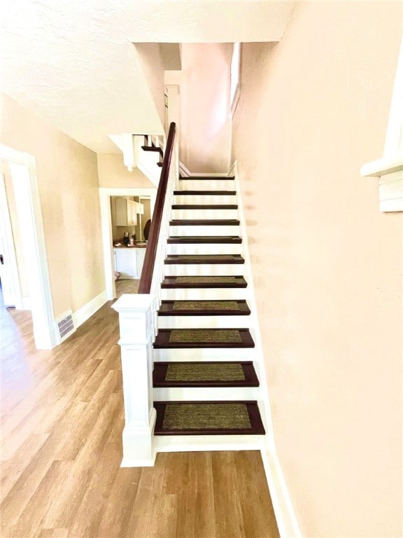 stairs with hardwood / wood-style flooring