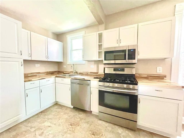 kitchen with white cabinetry, sink, wooden counters, and appliances with stainless steel finishes