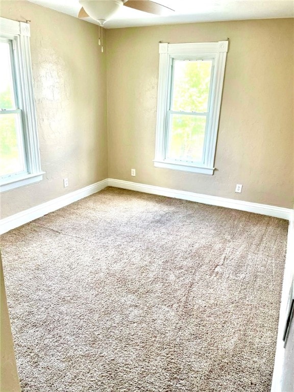 carpeted empty room with plenty of natural light and ceiling fan