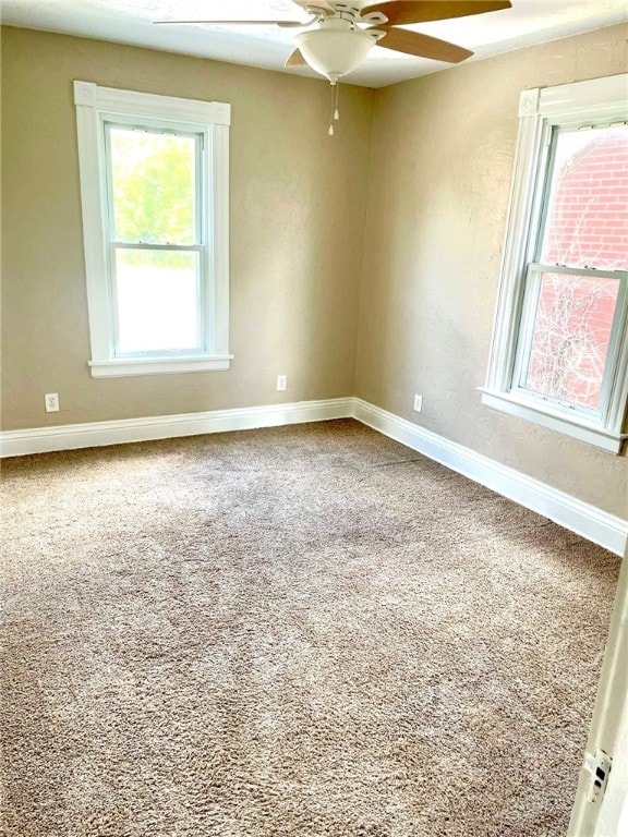 carpeted spare room featuring ceiling fan