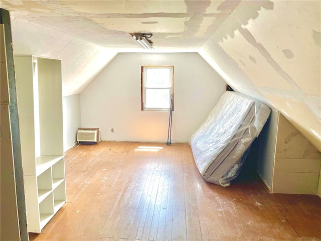 additional living space with lofted ceiling and hardwood / wood-style flooring