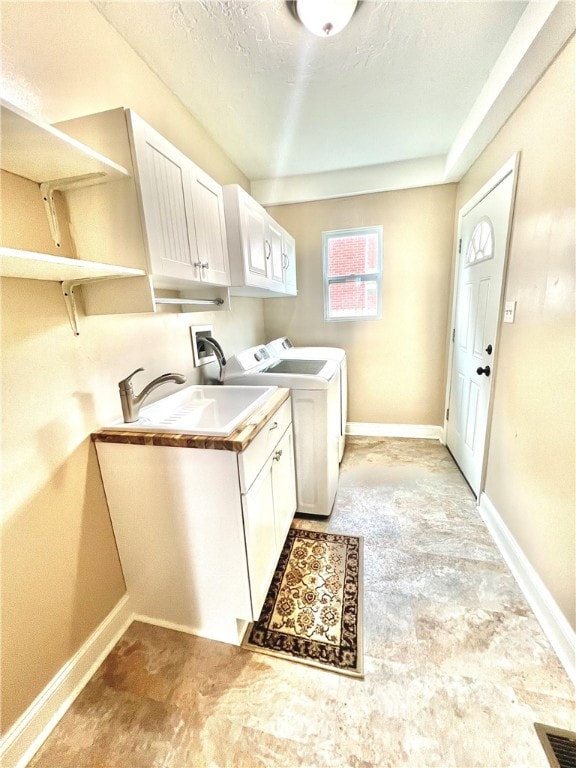 washroom with cabinets, sink, and washer and dryer